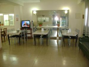 comedor con mesas y sillas y TV en Real Splendid Hotel en Buenos Aires