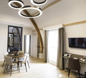 a dining room with a table and a chandelier at Impérial Palace in Annecy