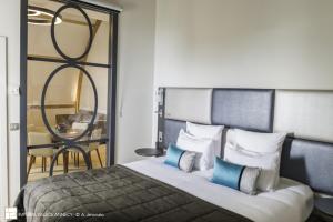 a bedroom with a bed with blue and white pillows at Impérial Palace in Annecy