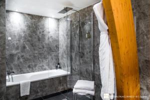 a bathroom with a shower and a bath tub at Impérial Palace in Annecy