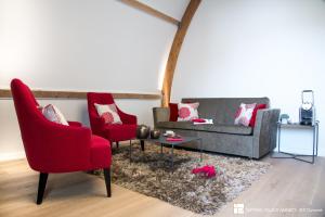 a living room with two red chairs and a couch at Impérial Palace in Annecy