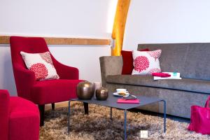 a living room with two red chairs and a coffee table at Impérial Palace in Annecy