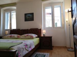 a bedroom with a bed and two windows at Apartment R&M Pula in Pula
