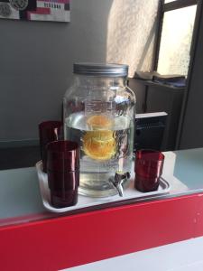 a jar filled with water and some cups on a counter at City Résidence Aix-en-Provence in Aix-en-Provence