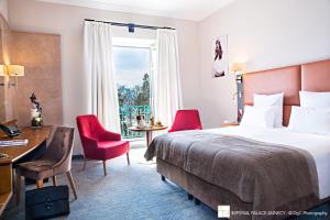 a hotel room with a bed and a desk and chairs at Impérial Palace in Annecy