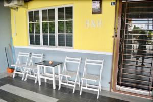 a group of chairs and a table in front of a building at H&H 2 Karaoke, Ice Hockey Table, Game Console in Melaka