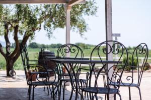 una mesa y sillas sentadas bajo un porche en Agriturismo Casale Sasso en Cerveteri