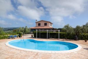 a swimming pool in front of a house at Agriturismo Casale Sasso in Cerveteri