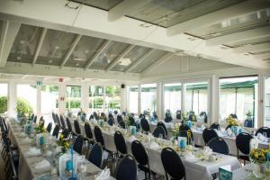un salón de banquetes con mesas y sillas blancas en Hotel am Schlosspark Herten, en Herten