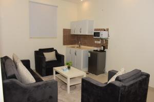 فندق الفرحان بنده في الرياض: غرفة معيشة مع كرسيين وطاولة