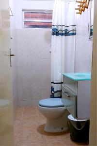 a bathroom with a toilet and a shower curtain at Pousada Via Maria in Cananéia