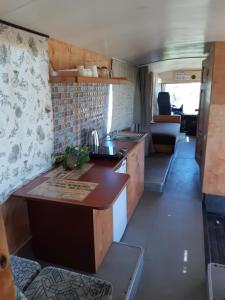 eine Wohnküche und ein Wohnzimmer mit einem Sofa in der Unterkunft Atomi CountryBus in Aucugals
