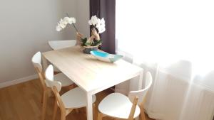a table with chairs and a table with flowers on it at Apartament Miarki 3 in Świnoujście