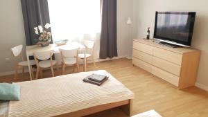 a living room with a television and a table with chairs at Apartament Miarki 3 in Świnoujście