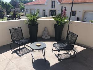 twee stoelen en een tafel op een patio met planten bij Villa Louis Victor in Dizy