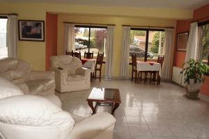 a living room with white couches and a table at Hotel Mirasierras in Merlo