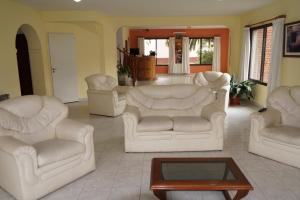 uma sala de estar com cadeiras brancas e uma mesa de centro em Hotel Mirasierras em Merlo