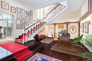 a living room with a staircase and red seats at Relais Villa Savarese in Sant'Agnello