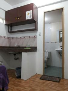 a bathroom with a sink and a toilet and a mirror at Budget Studio Unit in Makati in Manila