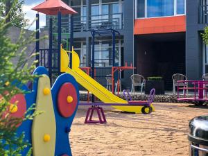 a playground with a yellow slide and aroller at Гостевой Комплекс ARTек in Tamchy