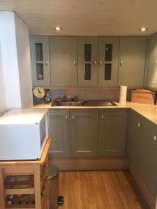 a kitchen with green cabinets and a microwave on a counter at San Michele Guest House in Poole