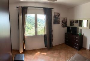 een woonkamer met een raam en een televisie bij La porta del Sole in Seborga