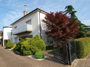 a white house with a black gate and bushes at Studio apartman Rest Nest in Čakovec