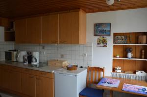 uma cozinha com armários de madeira e um frigorífico branco em Ferienhaus am Jakobsweg em Artstetten
