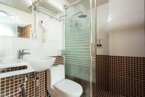 a bathroom with a toilet and a sink and a shower at Yangshuo Xingping This Old Place Li-River Inn in Yangshuo