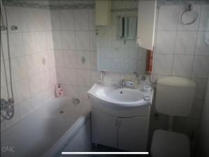 a bathroom with a sink and a toilet and a tub at Apartman AS in Livno +23 photos