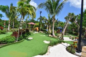 un campo da mini golf in un resort con palme di JUPITER WATERFALLS - NEWLY UPDATED - TIKI HUT, FIRE PIT, KITCHEN, POOL HEATER and MORE a Jupiter