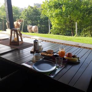 einen Tisch mit einem Teller Essen drauf mit einer Kuh in der Unterkunft Casa Rural Eguzkilore in Laukiz