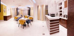 ein Esszimmer mit Tischen und gelben Stühlen in der Unterkunft Hotel Pierina in Budva