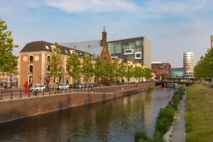 a river in a city with buildings next to a canal at BUNK Hotel Utrecht in Utrecht