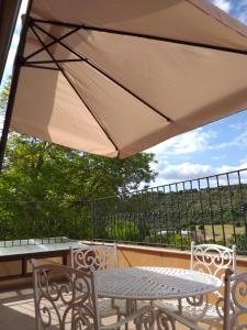 une terrasse avec une table, des chaises et un parasol dans l'établissement El Horno de Leopoldo, à Hueva