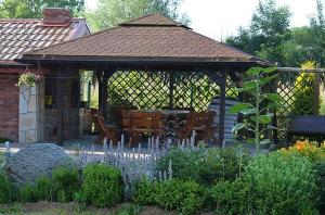 a gazebo with a table and chairs in a garden at Domek nad morzem in Będzino