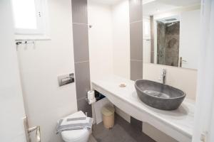 a bathroom with a sink and a toilet at Ifestia Hotel in Kamari