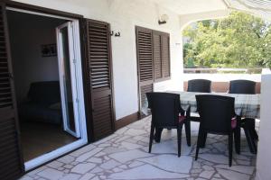 a dining room with a table and chairs on a patio at Apartments Matic in Njivice