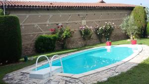 una piscina en un patio junto a una casa en LA FERME DU NIZON, en Valeilles