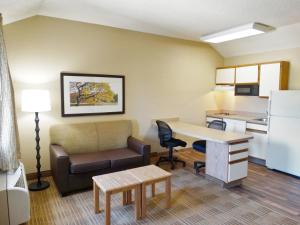 a living room with a couch and a desk and a kitchen at Extended Stay America Suites - Boston - Peabody in Peabody