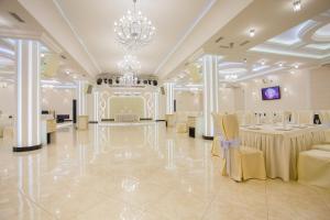un salón de banquetes con mesas y sillas y una lámpara de araña en Sweet Hall Hotel, en Krasnodar
