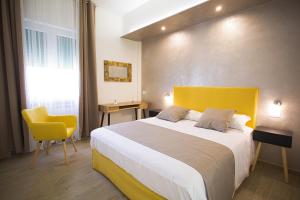 1 dormitorio con 1 cama grande y cabecero amarillo en PVrooms, en Campobasso