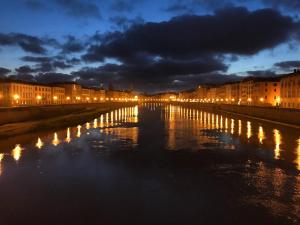 a view of a river at night with lights at Santamarta35 in Pisa