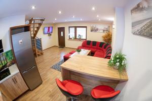 a living room with a table and red chairs at Noclegi u Bartka i Magdy in Solina