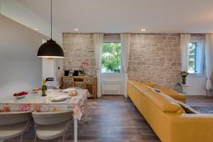 a living room with a table and a yellow couch at Apartment Oliveto Sibenik in Šibenik