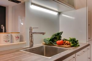 a kitchen sink with vegetables on a cutting board at Apartment Oliveto Sibenik in Šibenik +31 photos