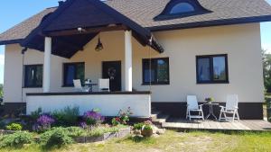 a house with two chairs and a table on a porch at Galikowo in Płaska