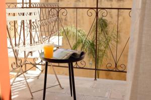 a glass of orange juice sitting on a table on a balcony at Veranda Rossa Suites in Rethymno Town