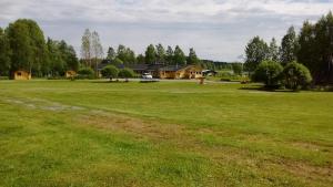 un gran campo de césped con una casa en el fondo en Lohirannan lomakylä, en Sukeva