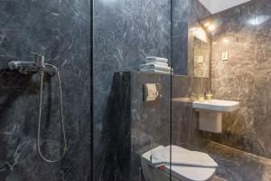 ein Badezimmer mit Dusche, Toilette und Waschbecken in der Unterkunft Top Floor View Penthouse in Cluj-Napoca + 37 Fotos
